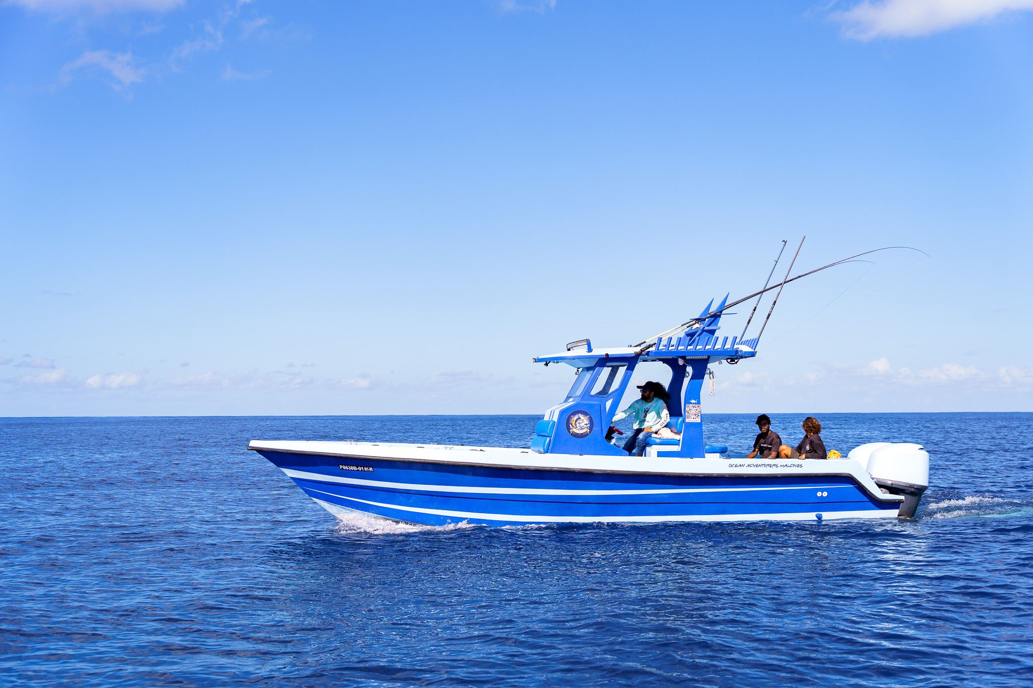 Center console sportfishing boat with outriggers deployed on deep blue ocean